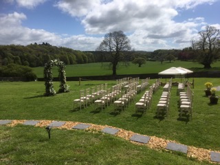empty chairs looking towards table with marquee behind