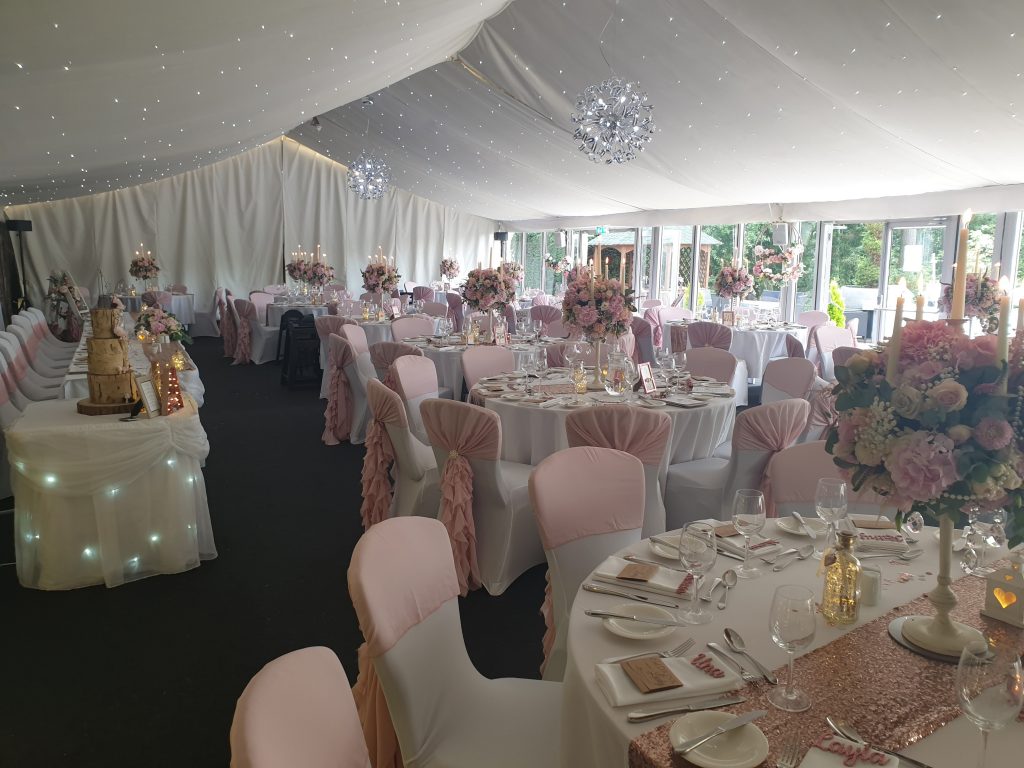 Inside a marquee with lots of fabric, table cloths, napkins and chaire covers