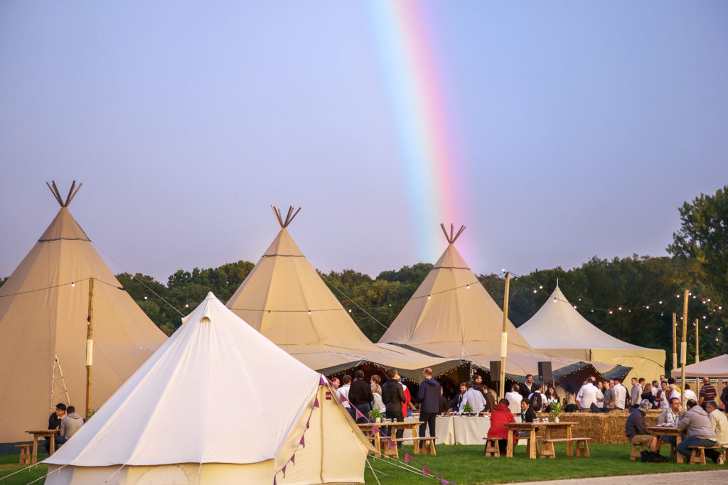 teepees and bell tents with a rainbow