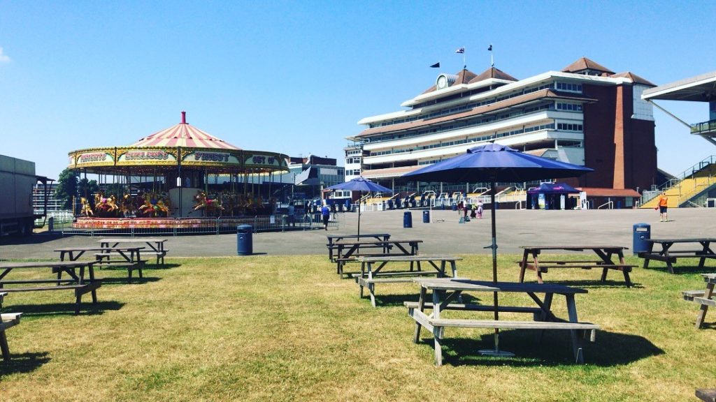 Buildings, carousel and picnic tables with parasols