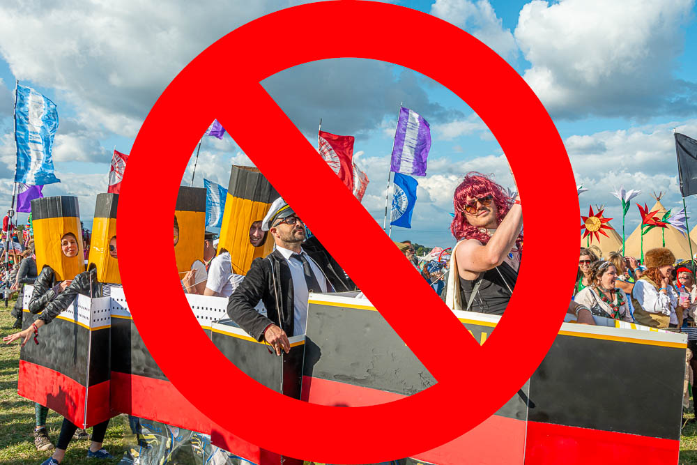 Festival goers in fancy dress in a cardboard titanic with a big red no entry sign over the top