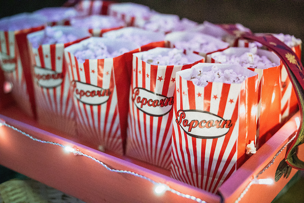 Popcorn in red and white striped paper bags with popcorn written on them